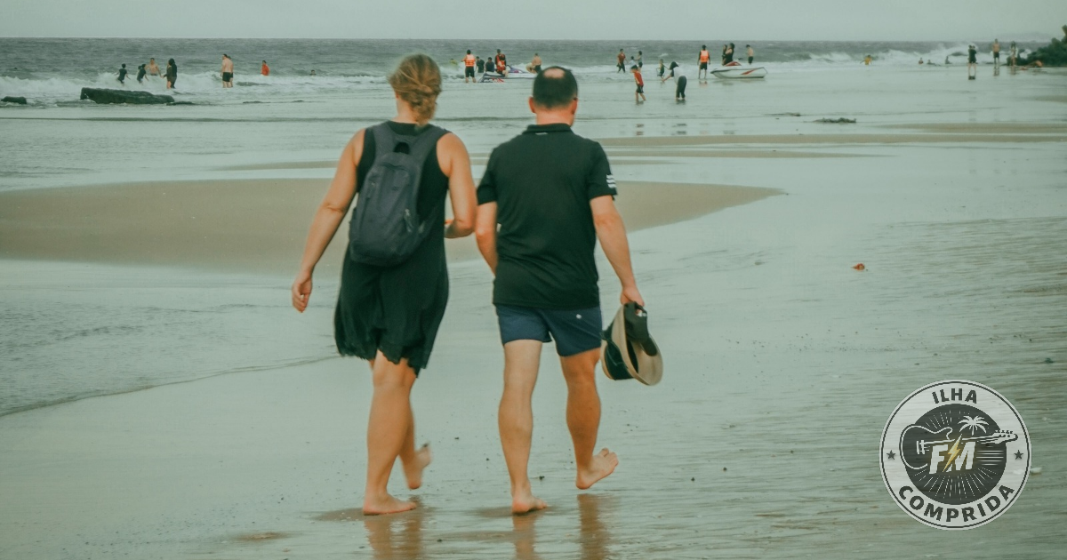 Turistas caminhando na praia de Ilha Comprida