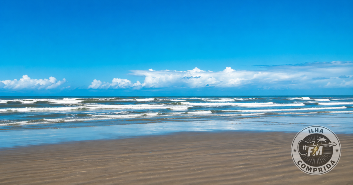Praia de Ilha Comprida com faixa de areia extensa, mar aberto e céu azul no litoral sul de São Paulo.